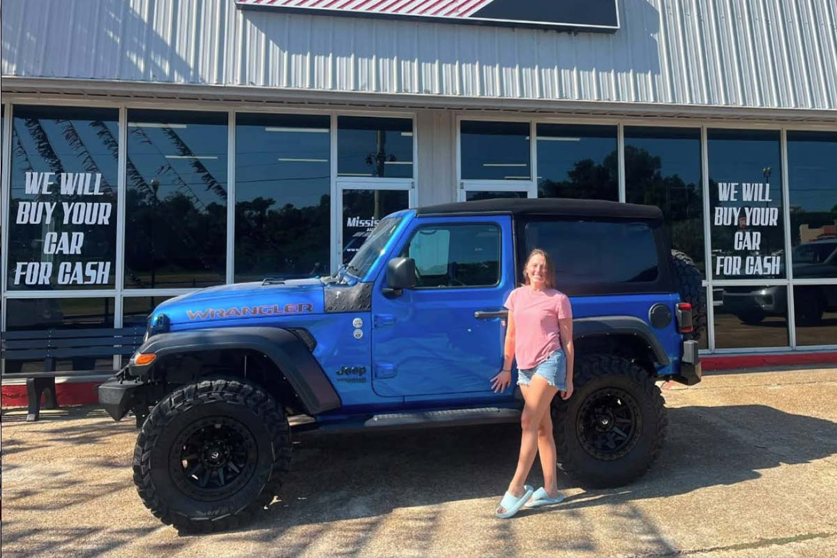 Customer with a blue Jeep at Mississippi Auto Direct