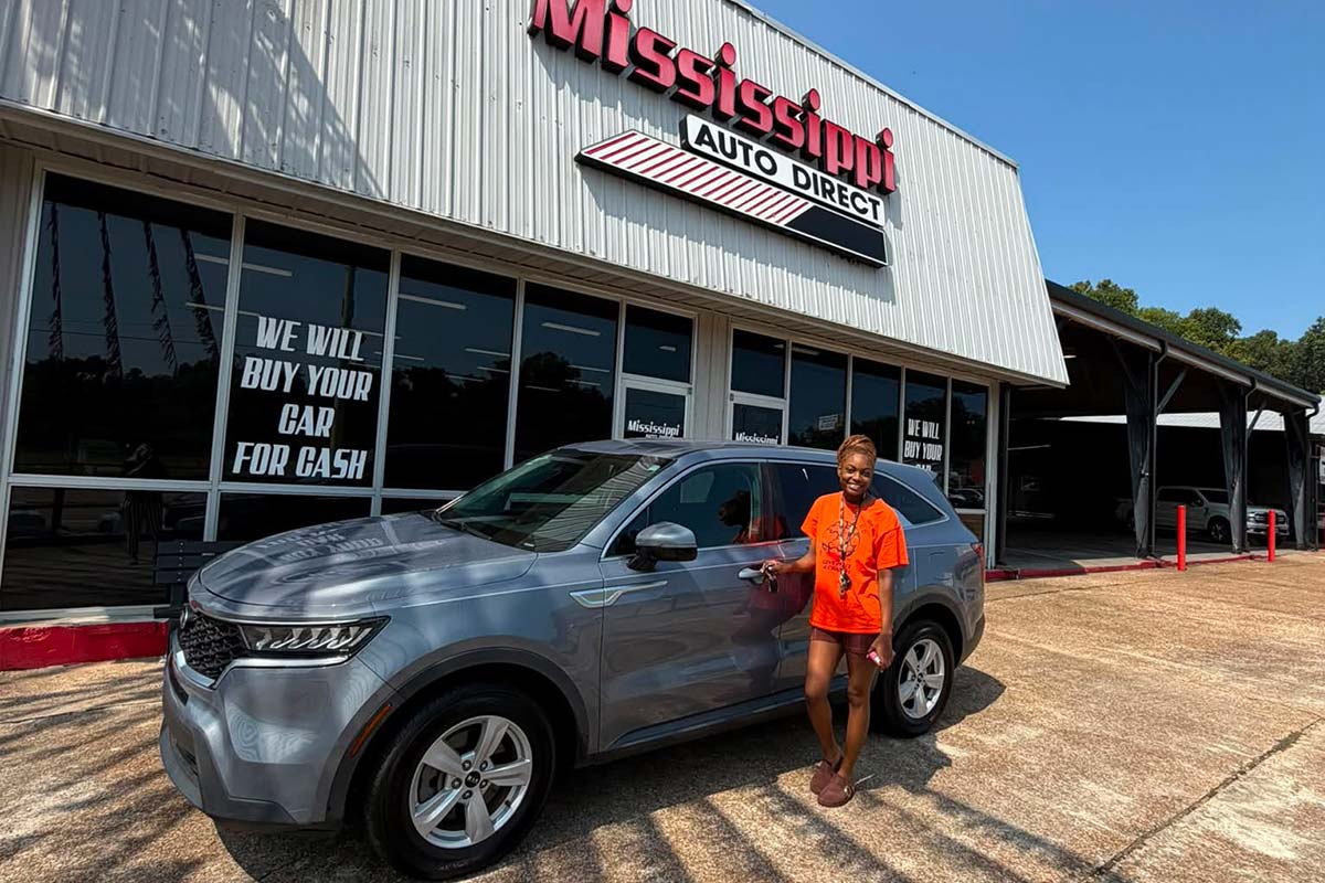 Customer beside an SUV at Mississippi Auto Direct